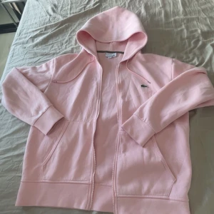 osa hoodie från Lacoste - Säljer en ljusrosa/rosa hoodie från Lacoste i storlek M men passar även L kan gå ner i pris så skicka prisförslag😁