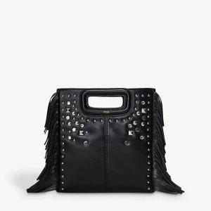 Svart handväska med nitar från Maje - Cool svart handväska från Maje i skinn med fransar på sidorna och massor av silvriga nitar och studs framtill. Väskan har ett inbyggt handtag och en fyrkantig form som ger en edgy vibe. Perfekt för dig som gillar detaljer och statement-accessoarer.