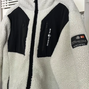 Sail Racing teddy jacka -  vit teddyjacka från Sail Racing, aldrig använd så nyskick. Materialet är mjuk fleece, skulle säga att det är mer än L än XL