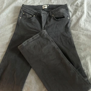 Svarta jeans från 157, raka ben - Snygga svarta jeans från 157 med klassisk femficksdesign och bootcut ben. Jeansen har en enkel look med silverfärgade nitar och en bakficka med lock och knapp. Perfekta för dig som gillar stilrena och tidlösa byxor.