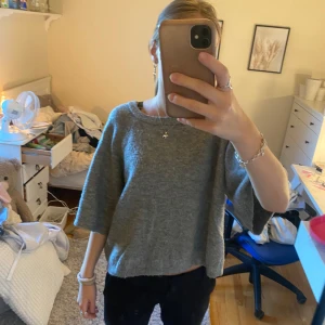 Grå stickad tröja med trekvartsärm - Mysig grå stickad tröja med avslappnad passform och trekvartsärmar.  Enkel design utan synliga detaljer eller mönster. Från lager 157 har inga defekter 