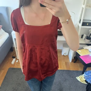 Röd glansig topp - Röd glansig topp från gina, men köpt secondhand. Aldrig använd av mig pga att den inte passa. Lite tecken på användning