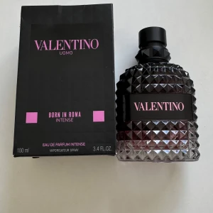 Valentino Uomo Born In Roma Intense 100ml - Valentino Uomo Born In Roma Intense EdP 100ml. Flaskan är mörk och har en cool nitar-inspirerad design i glas med svart och rosa detaljer. Parfymen är intensiv och exklusiv, perfekt för dig som gillar lyxiga dofter med attityd. Levereras med originalkartong.