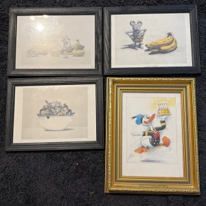 Konsttryck med Disney-tema - Fyra inramade konsttryck med lekfulla motiv inspirerade av Disneyfigurer som Kalle Anka och Musse Pigg. Perfekt för dig som gillar popkultur och vill ha något unikt på väggen! Passar både ungdomsrum och kreativa hem.