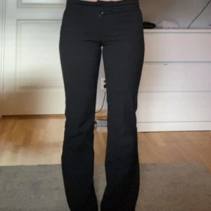 Svarta bootcut/straight kostymbyxor - Snygga svarta kostymbyxor med bootcut/straight snitt och normal passform. Byxorna har klassisk midja och stängs med dragkedja och knapp framtill. Perfekta till en stilren look och passar till många olika outfits.