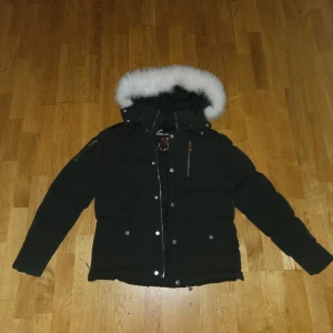 Svart Moose Knuckles dunjacka med pälskrage - Svart Moose Knuckles-jacka i storlek M med vit päls. Supervarm, tidlös och i väldigt bra skick. Nypris ca 10 000 kr, säljes för 3 500 kr (pris kan diskuteras). Kvitto finns tyvärr inte kvar, men jackan är givetvis 100% äkta. Fraktar samma dag som den köps.