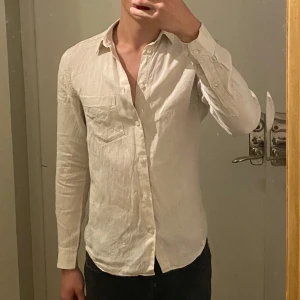 Beige linneskjorta  - Beige skjorta i linne från H&M Essentials,  Regular Fit. Skjortan har klassisk krage, bröstficka och knäppning framtill. 