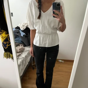 Vit blus med åtdragen midja - Säljer den slutsålda vita blusen från H&M med åtdragen midja och knytning på axlarna