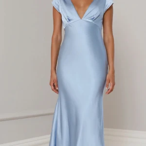 Ljusblå långklänning med öppen rygg - Elegant ljusblå långklänning i satin med v-ringad fram och en stilfull öppen rygg. Perfekt för speciella tillfällen så som bal. Endast testad, prislappen kvar