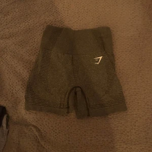 Grå träningsshorts från Gymshark - Snygga grå träningsshorts från Gymshark med en tight passform. Perfekta för gymmet eller löprundan. De har en diskret logga på sidan och är tillverkade i ett stretchigt material för maximal komfort.