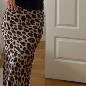 Leopardmönstrad kjol - supersnygg leokjol i satin. Passformen är otrolig, resorband i midjan som gör den stretchig. Storlek xs och sitter perfekt på mig som vanligtvis har xs/s. Lång och går ner till fötterna på mig som är 162. Använd fåtal gånger så i mycket fint skick, inga tecken på användning!Nypris 399, säljer för 240kr.