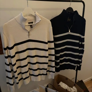 Randig tröja med dragkedja - Säljer en stilren randig tröja från H&M med dragkedja vid halsen. Finns i både mörkblå och vit basfärg med kontrasterande ränder. Tröjan är långärmad och tillverkad i bomull, perfekt för en avslappnad look. 1 för 150 och båda för 200.