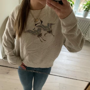 Beige stickad tröja med broderade tranor - Säljer en mysig beige stickad tröja med vackra broderade tranor på bröstet. Ett snyggt plagg som passar till det mesta. STORLEK - M PRIS går att diskutera! Skriv om du har frågor 🫶🤍