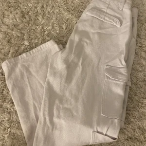 Beige cargopants - Säljer ett par stilrena beige cargopants med praktiska fickor på sidorna. Byxorna har en avslappnad passform och är perfekta för en casual look. Tillverkade i ett slitstarkt material som passar bra för vardagsbruk.