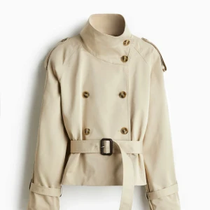 Beige trenchcoat med bälte - Intressekoll på den populära trenchcoaten. Oanvänd med lappar kvar. Jag har den i storlek L men har vanligtvis S & den passar mig bra. Om fler är intresserade skicka ett bud till mig så sälje jag den. (Använder INTE köpdirekt funktionen)