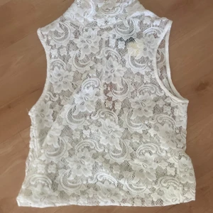 Vit spetstopp för fest - Säljer ett vackert vitt spetslinne med blommönster. Perfekt för fest! Från Vila och är små i storleken 💕