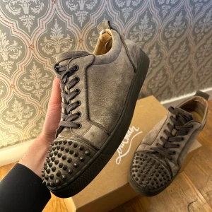 Gråa louboutins - Sjukt snygga loubs i bra skick, finns tecken på andvändning men inget som märks av när dom bärs, största defekten kan du se på sista bilden. Kommer i orginal förpackning med extra snören och nitar. Strl 44 men passar mig som brukar ha 43 utmärkt🙌🏻🙌🏻