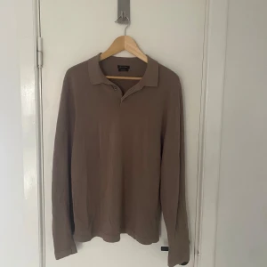Brun rugbytröja från Massimo Dutti - Säljer en stilren brun långärmad pikétröja från Massimo Dutti. Tröjan är tillverkad i bomull och har en klassisk krage med knappar. Perfekt för en avslappnad men ändå elegant look. Passar M utmärkt! Skriv om ni har några övriga frågor🙌