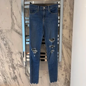 Blå jeans från Levi's - Säljer ett par blåa skinnyjeans med hål från Levi's. Storlek 25 ( sitter som s) köparen står för frakten!❤️