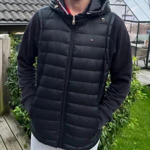 Svart väst från Tommy Hilfiger XS/S - Säljer en stilren svart väst från märket Tommy Hilfiger från NK Göteborg ” Avtagbar luva ” Köptes för 1799kr Mitt pris 449kr väldigt fint skick! Perfekt nu när värmen börjar närma sig, vid fler frågor är det bara att skicka 🙂