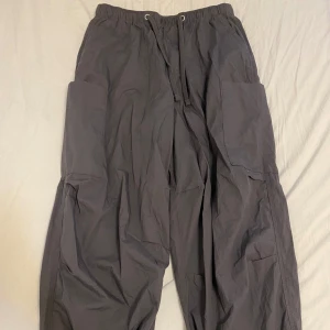 Svarta cargobyxor från ASOS DESIGN - ASOS cargobyxor – Svarta – Storlek [din storlek] Snygga och bekväma cargobyxor från ASOS i väldigt fint skick. Lätta i materialet, med resår i midjan och dragsko, stora sidofickor och justerbara benslut. Bara använda ett fåtal gånger – inga skador eller fläckar. Perfekta för en avslappnad vardagsstil eller streetwear-look.