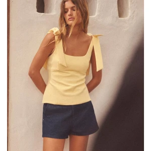 Gul topp från Zara - Snygg och trendig gul topp från Zara med breda axelband och knytband som ger en söt detalj. Perfekt för varma sommardagar. Helt ny med prislappen kvar!💕liten i storleken