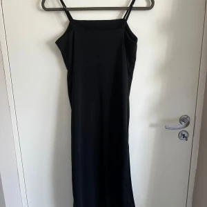Svart långklänning med spagettiband - Elegant svart långklänning med smala axelband och slits i sidan av ena benet. perfekt till sommaren. pris kan diskuteras ❤️ 