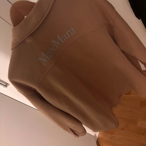 Beige sommar kavaj / jacka från Max Mara - Snygg beige overshirt från Max Mara med knappar framtill och två stora bröstfickor. Perfekt för lager-på-lager-stil. Den har en klassisk krage och långa ärmar, vilket gör den idealisk för både vår och höst.