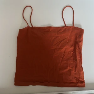 Orange linnetopp från Gina Tricot - Säljer en snygg orange linnetopp från Gina Tricot. Toppen har smala axelband och är perfekt för varma sommardagar. Enkel och stilren design som passar till det mesta. Perfekt för att lägga till en färgklick i garderoben!