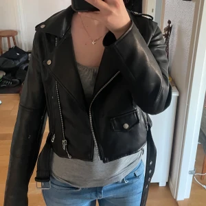 Svart skinnjacka med detaljer  - Snygg svart skinnjacka med dragkedja och knappar och andra detaljer🖤 Den är lite kortare i modellen, perfekt nu till våren, jätte fint skick 