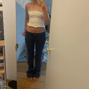Blå bootcut byxor - Säljer ett par mörkblå bootcut byxor i storlek XS. Byxorna har en klassisk femficksdesign med knapp och dragkedja framtill. Perfekta för en avslappnad stil.