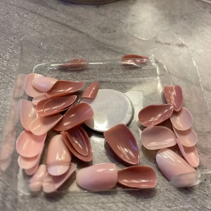 Rosa lösnaglar i olika nyanser - Säljer ett set med två olika sorter lösnaglar i olika nyanser, ett par ljusrosa och ett par mörkare rosa. Naglarna har en glansig finish och kommer i olika storlekar. Perfekt för en snabb och enkel manikyr hemma. Inget lim kommer med.❤️säljer för 35kr, pris kan diskuteras🥰(33 st naglar totalt)