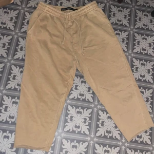 Beige mjukisbyxor - Säljer ett par bekväma beige kortare mjukisbyxor från The Black Label Collection. Byxorna har en elastisk midja med snörning för justerbar passform