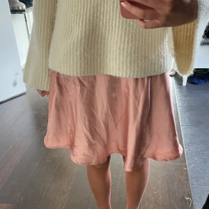 Rosa kjol i satin - Säljer en söt rosa kortkjol i satin. Kjolen har en mjuk och glansig yta som ger en lyxig känsla. Perfekt till sommaren. Den har en hög midja men man kan vika ner till låg midja, se sista bild!🩷