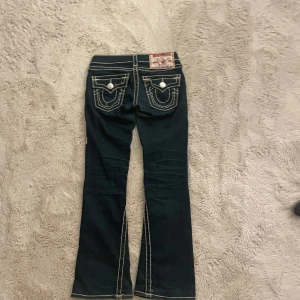 Mörkblå true religion jeans  - Snygga mörkblå jeans från True Religion med vita kontrastsömmar och dekorativa fickor, dom är lite korta på mig , skulle nog passa någon som är ca 155-160cm🩷