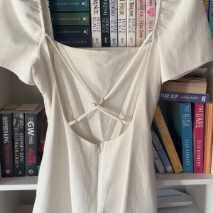 Vit klänning med öppen rygg - Elegant vit Zara klänning med korta ärmar och en stilren öppen rygg med snörningsdetaljer. Perfekt för sommarens festligheter. Klänningen har en enkel och chic design som passar många tillfällen. Passar utmärkt till både Student och Skolavslutning🤍