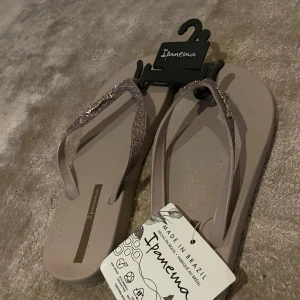 Glittriga sandaler från Ipanema - Snygga sandaler från Ipanema med glittriga remmar. Perfekta för sommardagar och till stranden. USA storlek 7, ungefär storlek 38. Sulan inuti sandalen mäter 24 cm. 