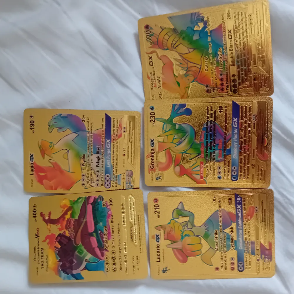 Samling av Pokémon GX-kort med guldfärgad design. Kort inkluderar olika Pokémon med färgglada illustrationer och detaljerade attribut. Perfekt för samlare eller Pokémon-entusiaster som vill utöka sin kortsamling med unika och iögonfallande kort.. Böcker.