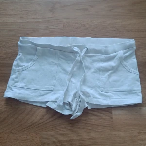 Vita low waisted shorts  - Säljer ett par vita shorts low waisted mjukis shorts. Perfekta för en avslappnad stil under varma dagar.