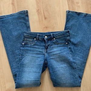 Blå bootcut jeans HM PRIS KAN DISKUTERAS - Säljer ett par klassiska blå bootcut jeans med fem fickor och dragkedja. Jeansen har en normal passform upptill och vida ben nertill. Perfekta för dig som gillar en retroinspirerad look. Midjan är lowwaist och materialet är klassisk denim. Älskar dessa men kommer intr till användning slutsålda överallt!!🩷
