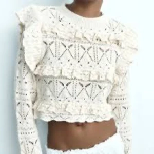 Beige stickad croppad tröja med volang - Superfin beige stickad croppad tröja från Zara, med volangdetaljer och hålmönster. Tröjan har långa ärmar och en rund halsringning. Storlek M men skulle också funka bra för  dig som har S🤍🤍