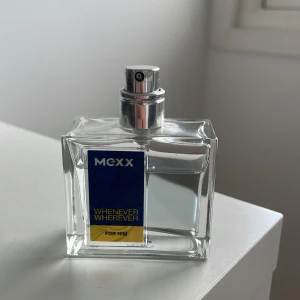 Whenever Wherever For Him parfym från Mexx - Fräsch herrparfym från Mexx i en stilren, transparent glasflaska med silverfärgad spraykork. Flaskan har en blå och gul etikett med texten 'Whenever Wherever For Him'. Perfekt för dig som gillar citrusdoft och modern design. PRISET KAN DISKUTERAS
