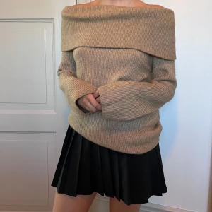 Jättefin Beige offshoulder stickad tröja - Säljer en beige stickad tröja med bred offshoulder-krage. Tröjan har lång ärm och är mjuk och skön i materialet. Supersnygg! Xs men passar större storlek också då den är så stretchig.