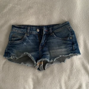 Blå jeansshorts från Divided - Säljer ett par blå jeansshorts från Divided (h&m) Shortsen har låg midja. Säljer då de är för små. Perfekta för varma dagar!