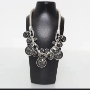 Statement halsband med stora glittriga stenar - Säljer ett maffigt statement halsband i silverfärg med stora, runda glittriga stenar. Halsbandet har en tjock kedja och flera stora, klara stenar som ger en lyxig känsla. Perfekt för att lyfta vilken outfit som helst!