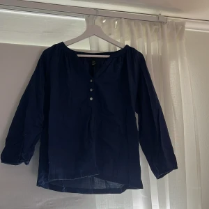 Mörkblå blus med knappar strl 36, 89kr - Säljer en mörkblå blus med tre knappar framtill och lätt v-ringning. Blusen har långa ärmar och är tillverkad i ett tunt, mjukt tyg som ger en luftig känsla. Perfekt för dig som gillar en enkel men stilren look. Storlek 36, men passar 38 och 40 också. Jag säljer denna för 89 kr + frakt. 