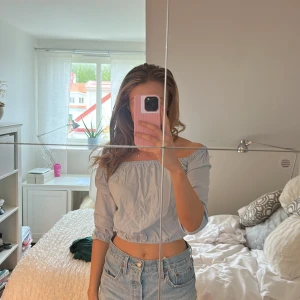 Ljusblå offshoulder blus - Säljer en ljusblå blus med offshoulder och trekvartsärm. Toppen är croppad och har en avslappnad passform, perfekt till jeans eller kjol. Superfin till vår och sommar!