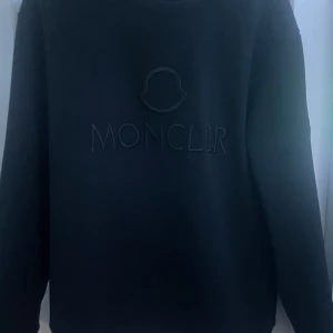 Svart sweatshirt från Moncler - Säljer en svart sweatshirt från Moncler med svart broderad logga på bröstet Moncler patch på ärmen. Skönt material på insidan som visas på sista bilden 
