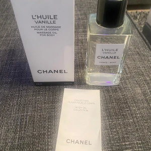 L'Huile Vanille massageolja från Chanel - Exklusiv massageolja för kroppen med vaniljdoft från Chanel. Kommer i en elegant, genomskinlig glasflaska med svart lock och tillhörande vit kartong. Oljan är en del av Chanels Body Oil Collection.