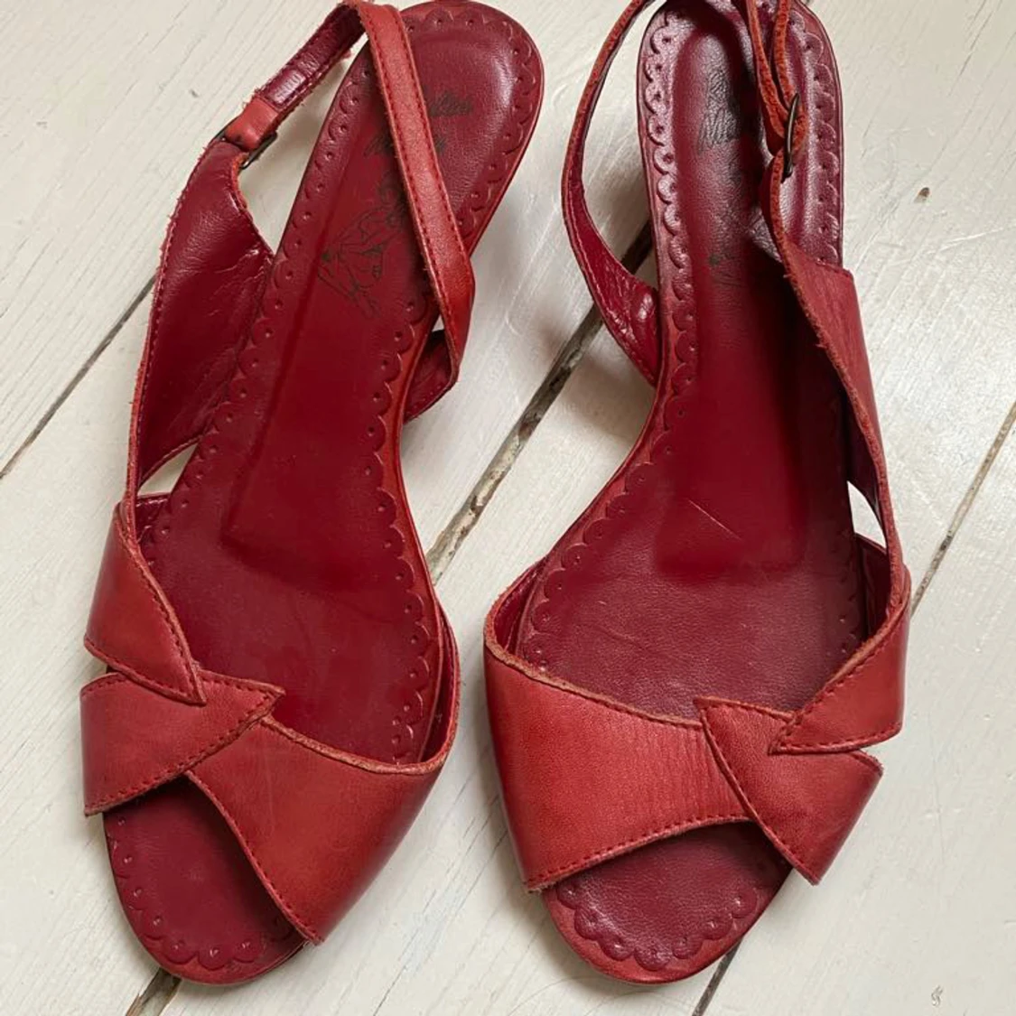 Röda sandaler med öppen tå och rosettdetalj